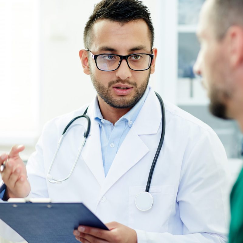 Young doctor consulting one of patients after treatment or examining